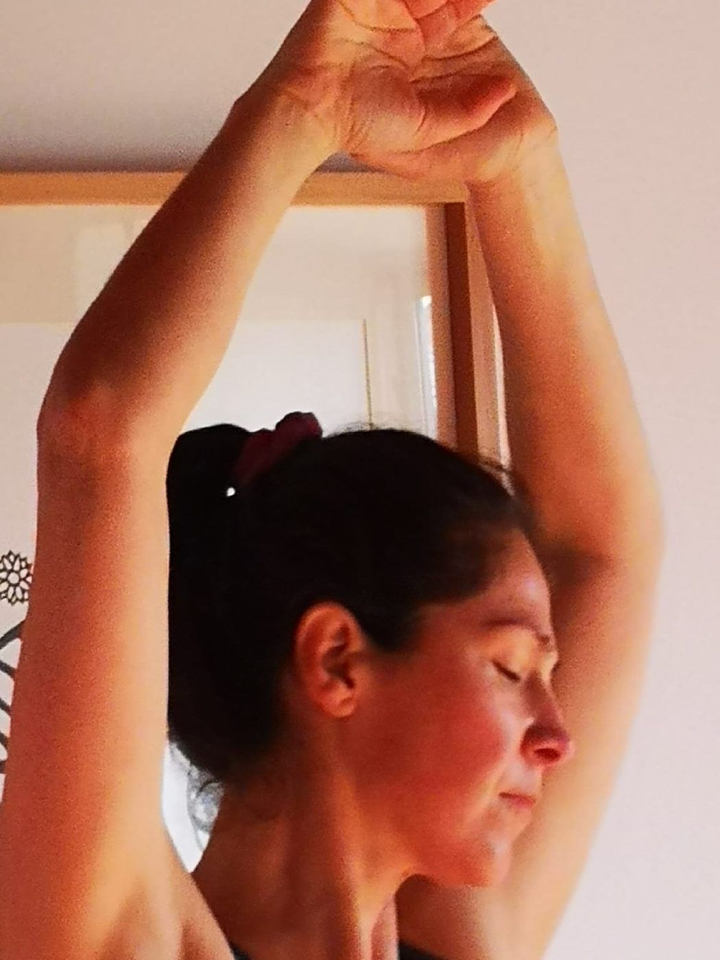 Participante danzando con los brazos en alto y los ojos cerrados