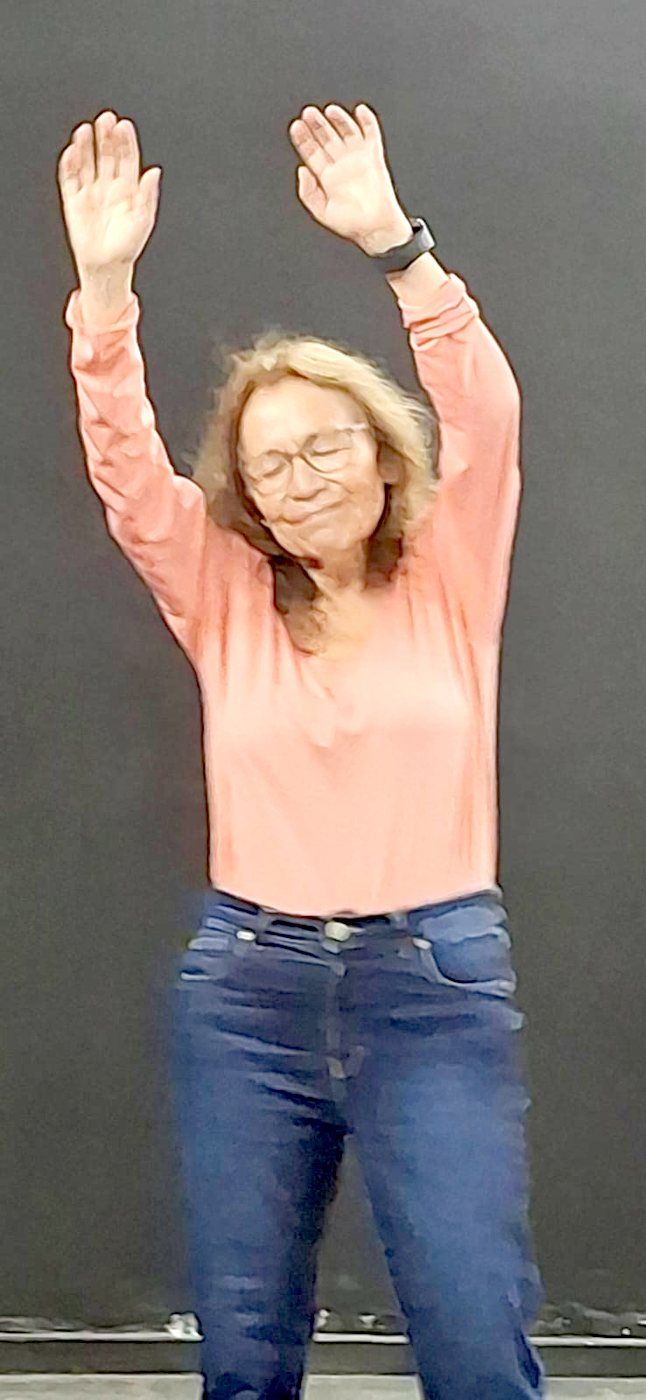 Participante danzando con los brazos en alto